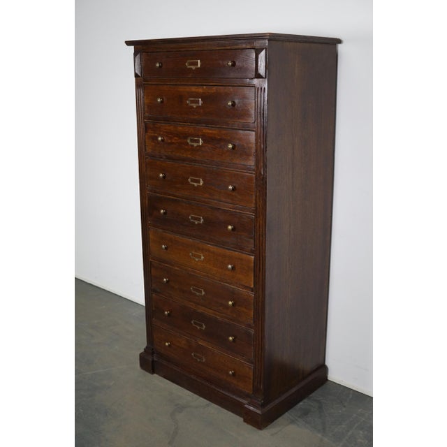 The cabinet is made from oak and features nine large practical drawers with brass pulls and name card holders. The...
