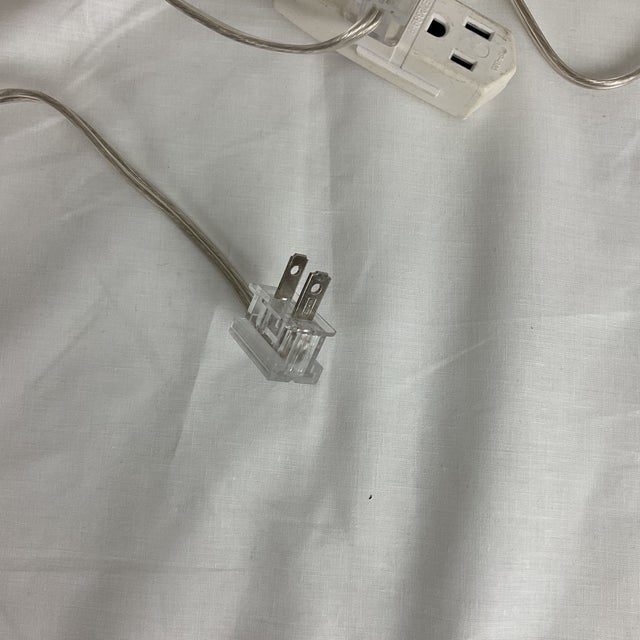 A sophisticated pair of sculptural table lamps crafted in glossy white glazed ceramic, featuring a beautifully turned,...