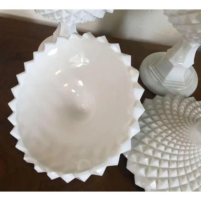 Vintage pair of large milk glass covered fruit bowls with an overall sawtooth design. Each bowl raised on a tall stem....