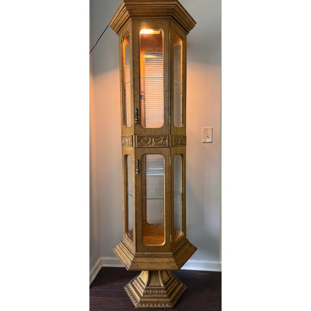 Elevate a room with this striking vintage Hollywood Regency hexagonal curio vitrine cabinet, finished in an antiqued...
