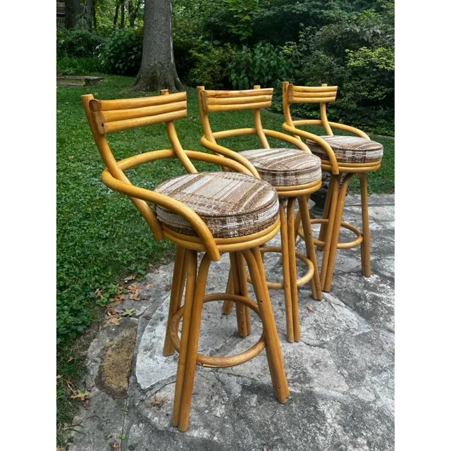 Gorgeous three strand rattan bar stools with arch armrests and legs. These unique vintage bamboo stools in the style of...