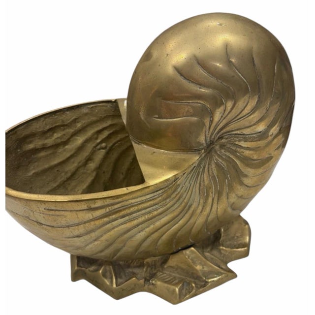 Beautiful vintage brass bowl designed in the form of a nautilus shell, featuring deeply incised spiral detailing and a...
