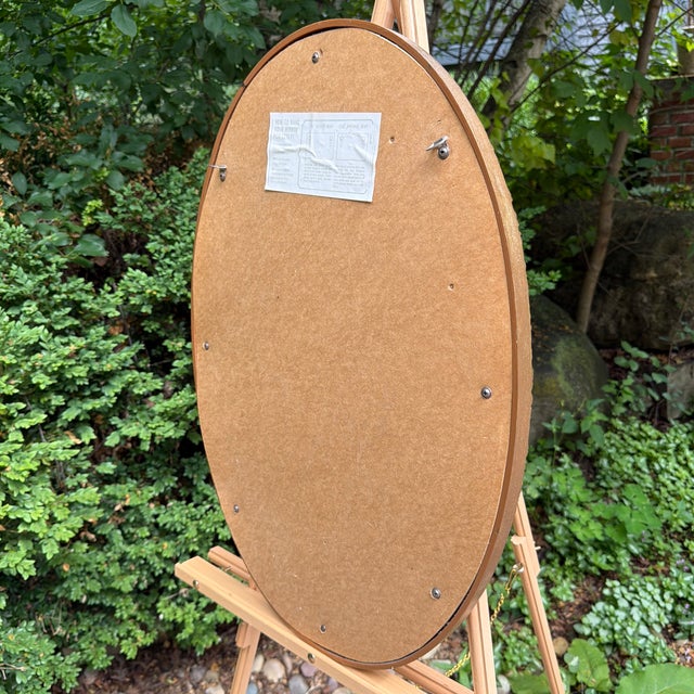Add a touch of timeless mid-century glamour to your space with this striking Hollywood Regency oval wall mirror...