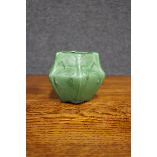 Attributed to Van Briggle, this Arts & Crafts pottery vase features a matte green glaze with raised luna moth decoration....