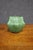 Attributed to Van Briggle, this Arts & Crafts pottery vase features a matte green glaze with raised luna moth decoration....