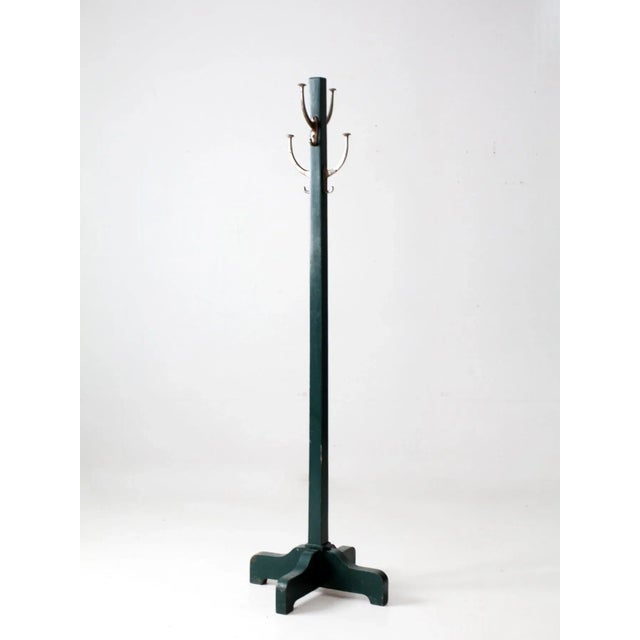 A vintage wooden wall-mounted coat rack featuring a rich teal-green finish and four silver-tone double hooks. The...