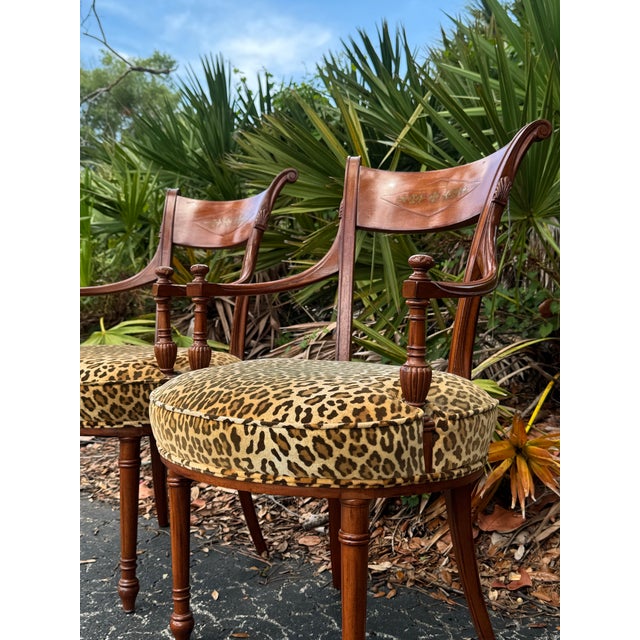 A striking pair of French Regency-style armchairs, beautifully crafted in richly toned rosewood and accented with elegant...
