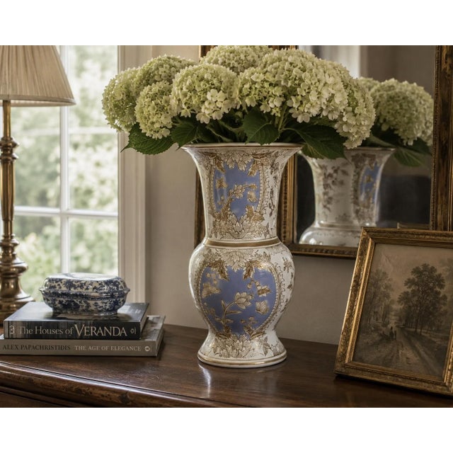 A decorative late-20th-century porcelain vase with an elegant baluster body, flared trumpet neck, and softly periwinkle-...