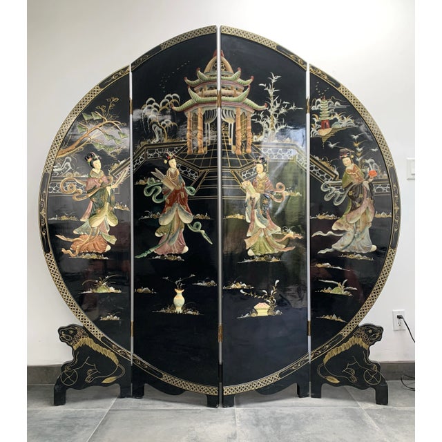 A mid-century, black lacquer, chinoiserie, round room divider/screen consisting of 4 panels on painted lion legs. The...
