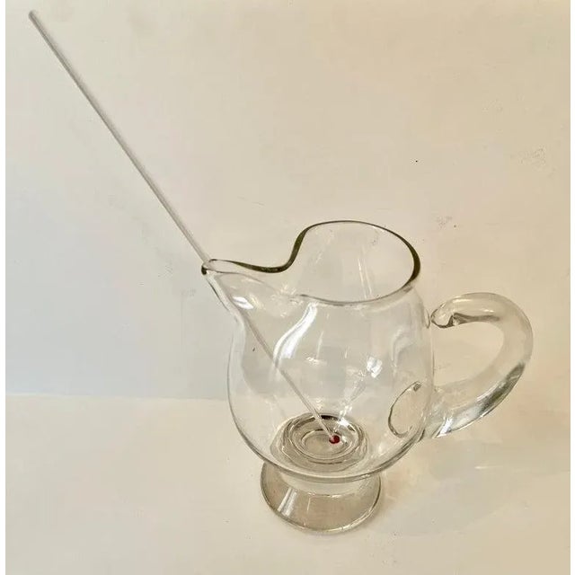 A wonderful tall Martini pitcher. What makes this pitcher unique is it's very thick and attractive base. mThe stirrer is...