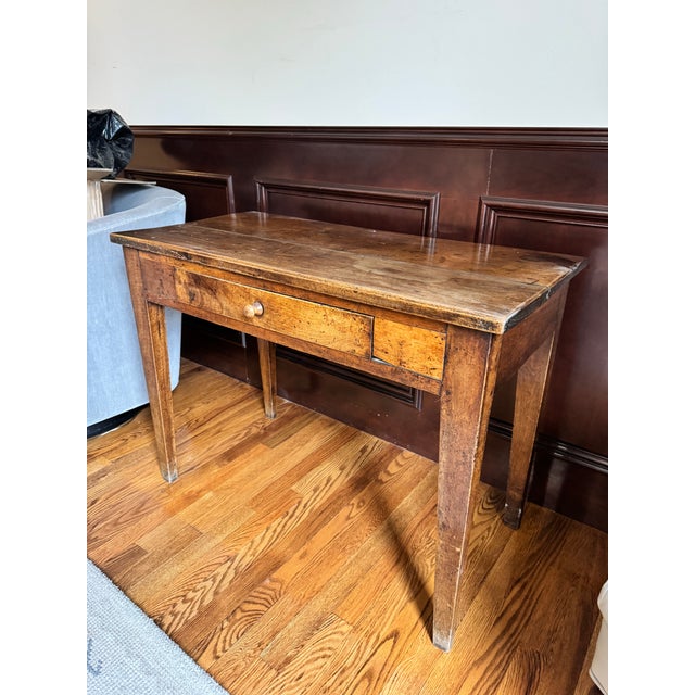 The walnut table of provincial pegged construction having a rectangular plank top over the confirming case with one long...