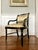 These vintage black lacquer Regency-style chairs feature elegant rounded arms and gold detailing on arms, back, and...