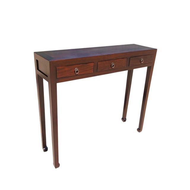 This vintage wooden console table features three side-by-side drawers across the front, each detailed with a traditional...