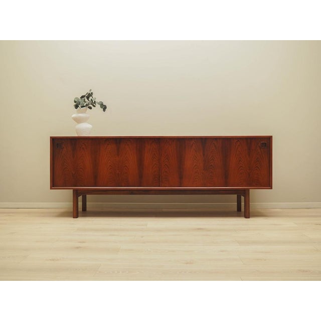 The sideboard was made in the 1970s by the renowned Danish manufacturer Omann Jun. The structure is covered with rosewood...