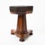 An Empire piano stool made in Boston around 1830, its octagonal seat set on a fluted, tapering rosewood pedestal. The...