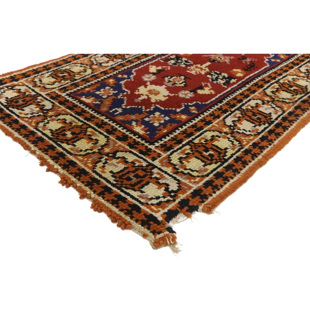 Vintage European Rug. This hand-knotted wool vintage European rug features an all-over botanical medallion. It is enclosed...