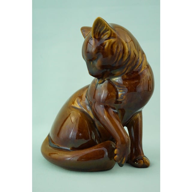 Item description: A stunning sculpture depicting a seated cat, made of vitrified majolica, crafted and signed under the...