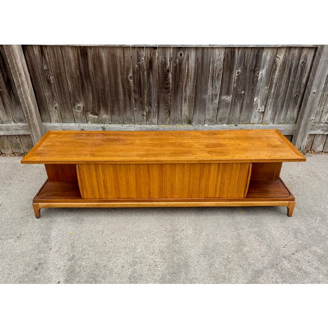 Very rare walnut coffee table from Lane's "Rhythm" collection. Features two tiers and a tambour door to close off one end...