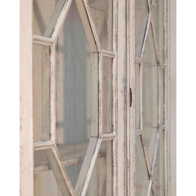 An elegant European two-part vitrine cabinet dating to circa 1790, distinguished by its refined proportions and finely...