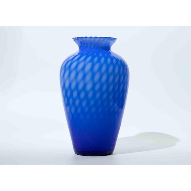 A beautifully crafted Murano glass vase featuring a vivid gradient of cobalt to electric blue, enriched by a dynamic optic...