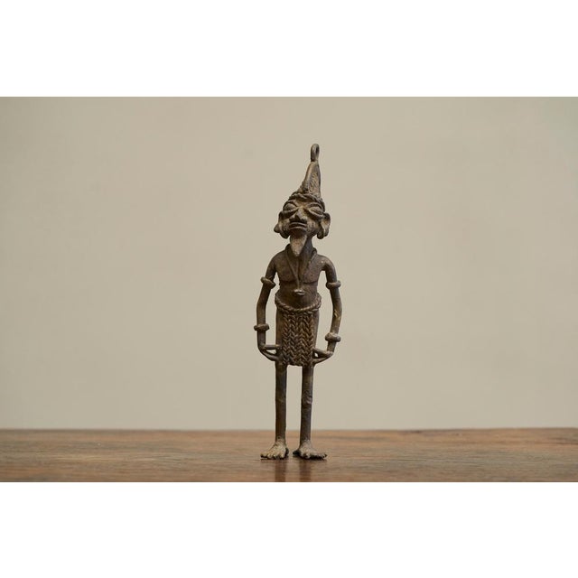 Early 20th Century West African Tribal Figurine in Cast Brass. Very distinct early to mid 20th century tribal figurine in...
