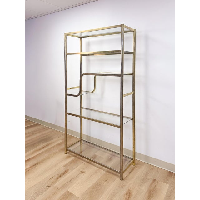 This gorgeous vintage Milo Baughman style brass toned shelf is a sleek and glamorous display piece that brings serious...