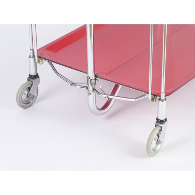 Bright and colourful red bar cart made in Germany in the 70's from the brand Gerlinol. It has a chrome metal...
