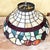 Large Tiffany-style leaded stained-glass pendant shade featuring a colorful fruit-and-leaf border with grapes, pears and...
