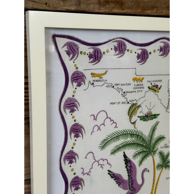 A charming vintage Florida souvenir handkerchief featuring a whimsical illustrated map of the Sunshine State, complete...