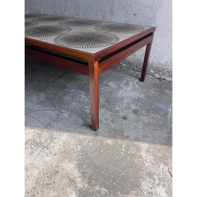 A striking extra-large Danish coffee table dating from the 1970s, featuring a beautifully crafted wooden frame and an...