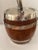 English oak with silver plated strapping, handle and cover ice bucket. White ceramic liner. Measures 6" tall, 5.5" wide....