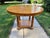 An Empire-style large round extension dining table by Baker Furniture with a glossy fruitwood top, reeded apron, four...