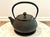 Antique cast Iron Teapot from Japan. Known as a Tetsubin Pot. Includes strainer insert and matching trivet. The teapot is...