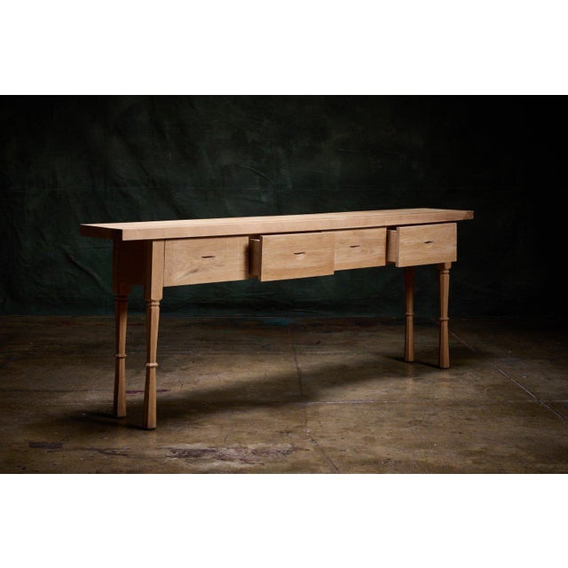 This is a contemporary European studio-made oak console table offering a sturdy and elegant surface for display or...