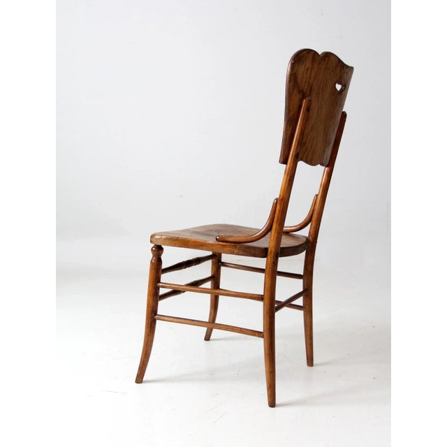 This antique oak accent chair features a stunning veneer backrest with a cutout design. The Victorian style chair also...