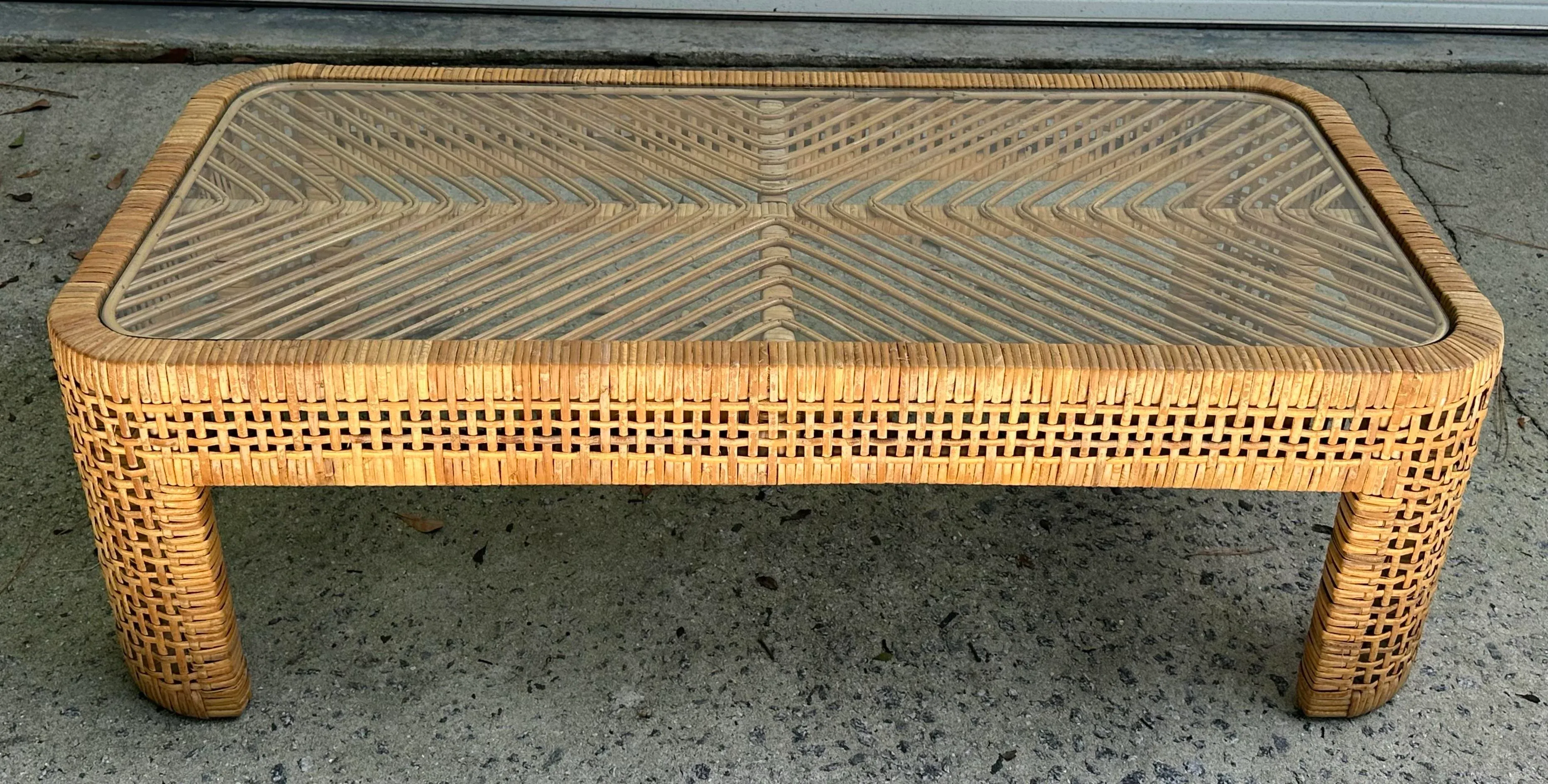 Woven Rattan Coffee Table With Glass Top Over Chevron Pattern