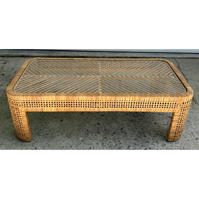 Vintage rattan and bamboo coffee table. Rectangular with softly rounded corners and curved legs. The woven base is topped...