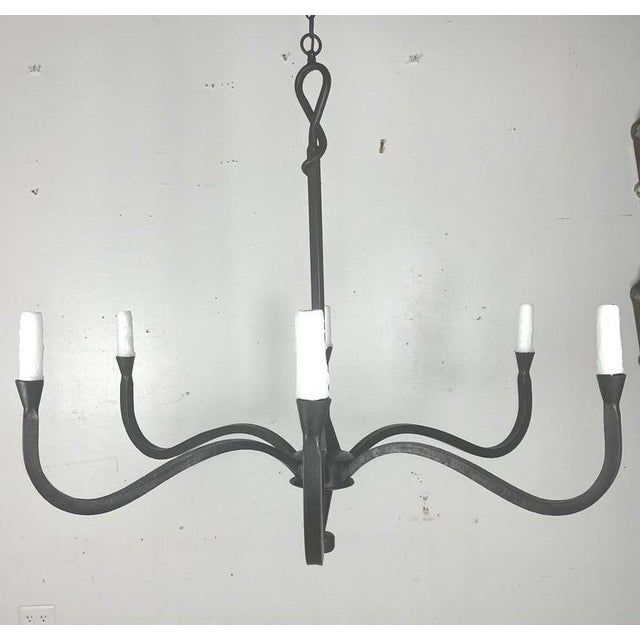 This six light chandelier has a minimalist and elegant design, crafted from wrought iron. It features six arms, extending...