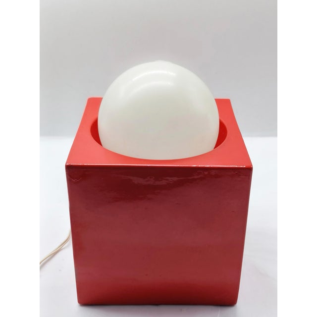 A rare table lamp produced by the Italian firm Il Picchio. The base is made of glossy red glazed ceramic and features a...