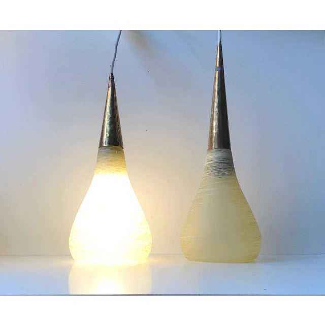 This is a pair of Italian pendant lamps from the 1970s. The set is composed of organically shaped threaded glass shapes,...