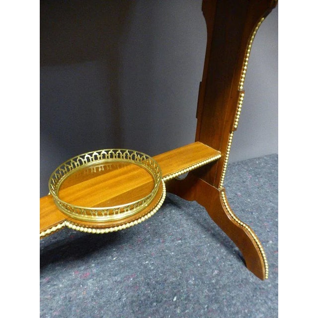 Table of living room in satin veneer and mahogany with decoration of flowers and nets. It rests on two double-legged legs...