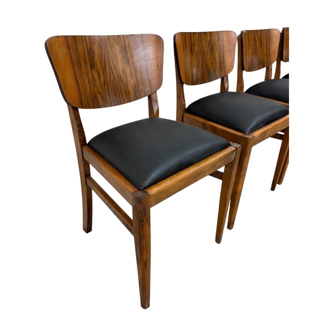 Elevate your dining space with this sleek set of four Mid-Century Modern rosewood dining chairs. Showcasing rich, dramatic...