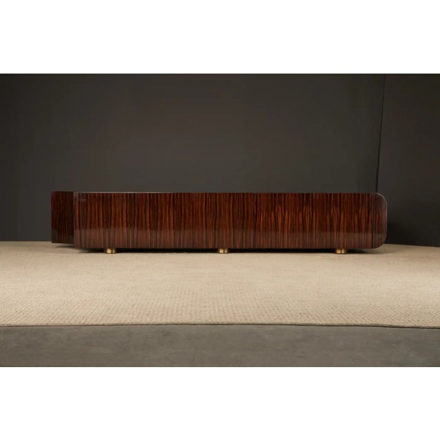 This monumental Macassar ebony and brass credenza by Leon Rosen for Pace Collection, custom made for Johnny Carson circa...