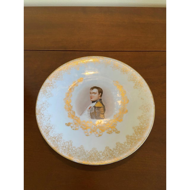 A striking antique Napoleon portrait plate featuring a finely rendered image of Napoleon in uniform, surrounded by a 22k...