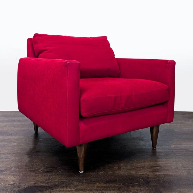 This stylish lounge chair features a bold red fabric, comfortable seat and back cushions, and sturdy wooden legs. Perfect...