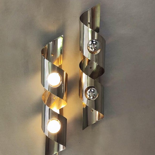 Set of two wall lamps with a futuristic design from the 1960s. Spiral structure in curved stainless steel sheets. They...