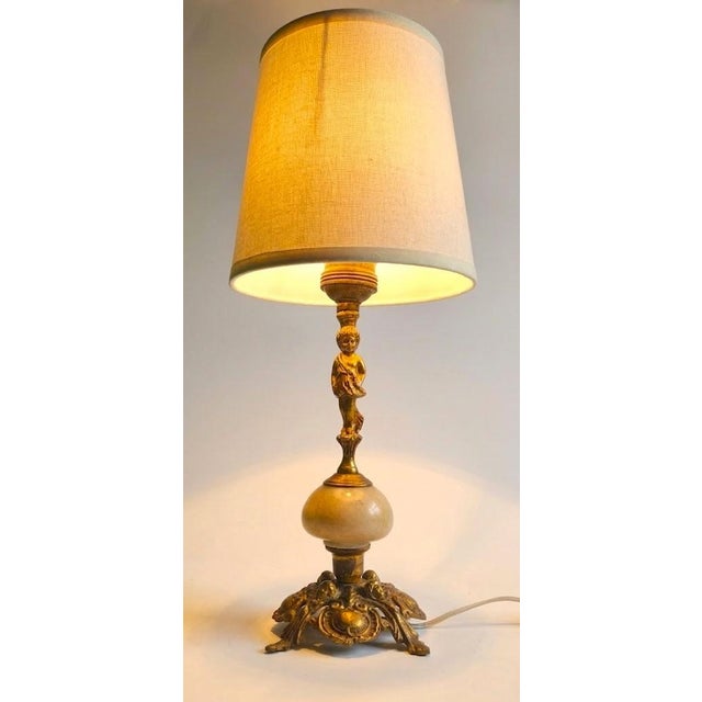 A beautiful Neoclassical gilded bronze lamp of Italian origin, circa 1920s–1950s. This lamp begins at the base, a marvel...