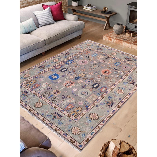 Enhance the ambiance of your home with this magnificent Persian-influenced Turkish hand-knotted rug made by skilled...