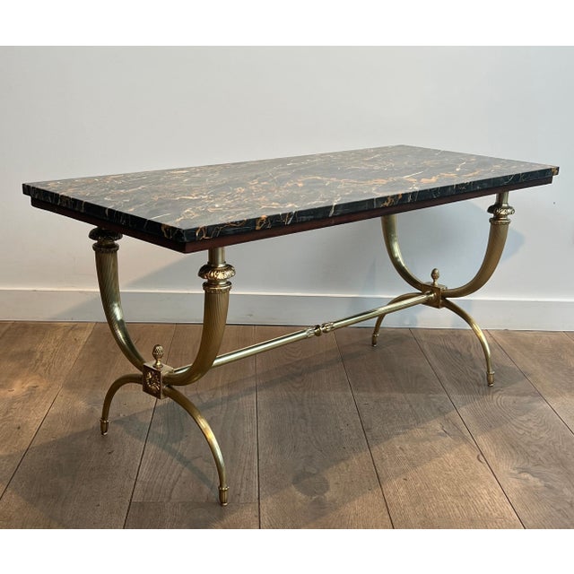 This beautiful and elegant neoclassical-style coffee table is made of bronze and brass with a black and gold marble top....