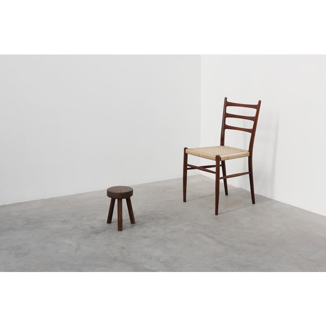 A characterful rustic oak tripod stool from France, dating to around 1900. This small, sculptural piece embodies the quiet...